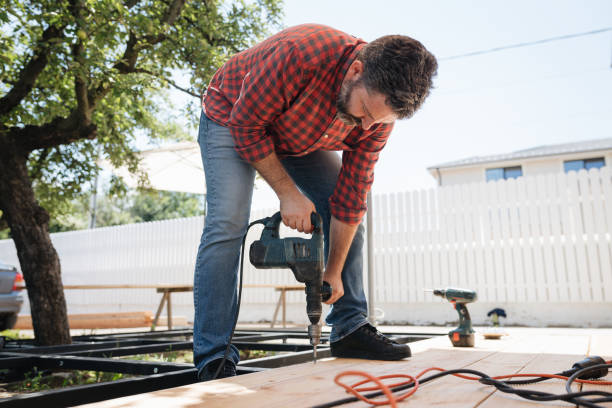 Carpenter installing a wood floor outdoor terrace in new house construction site