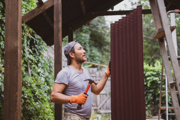 Man building roof and holding hammer and roof material onduline